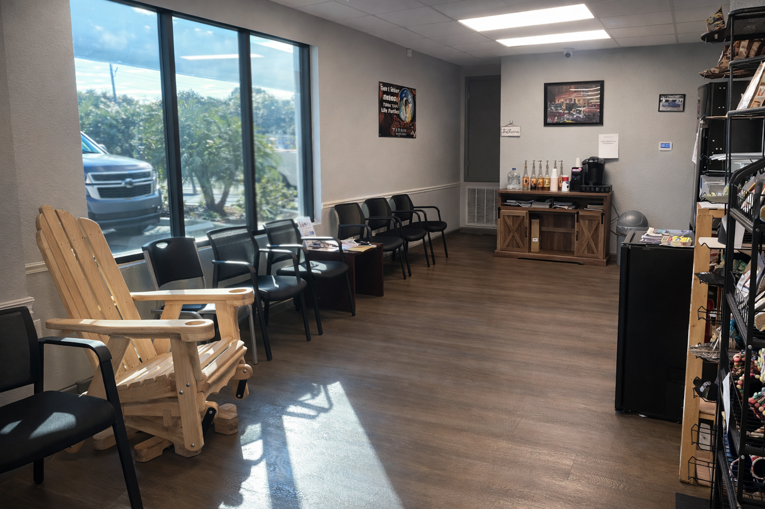Elite Automotive comfortable waiting room with Adirondack chair, modern seating, and coffee station